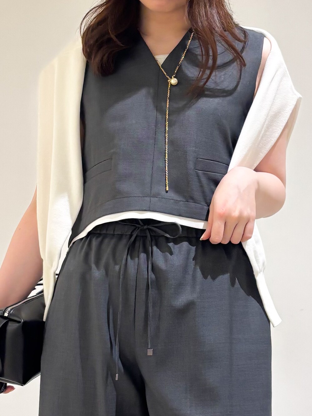 グレー系のその他パンツ、ブラック系のサンダル、グレー系のタンクトップを着用したレディースの夏コーディネートの6枚目の写真