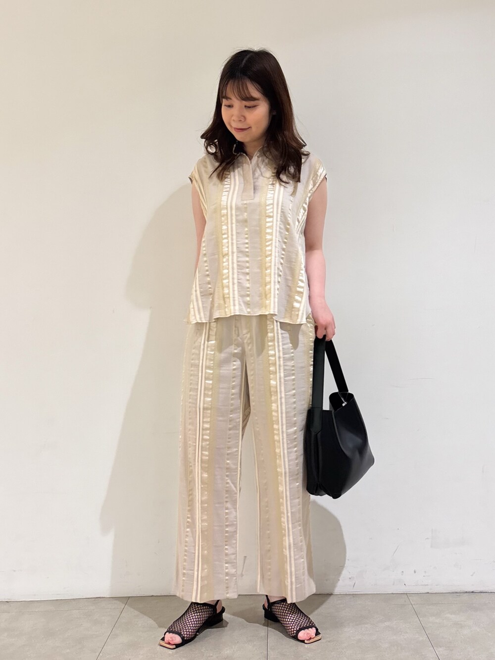 ベージュ系のシャツ/ブラウス、ベージュ系のその他パンツ、ブラック系のサンダルを着用したレディースの夏コーディネートの5枚目の写真