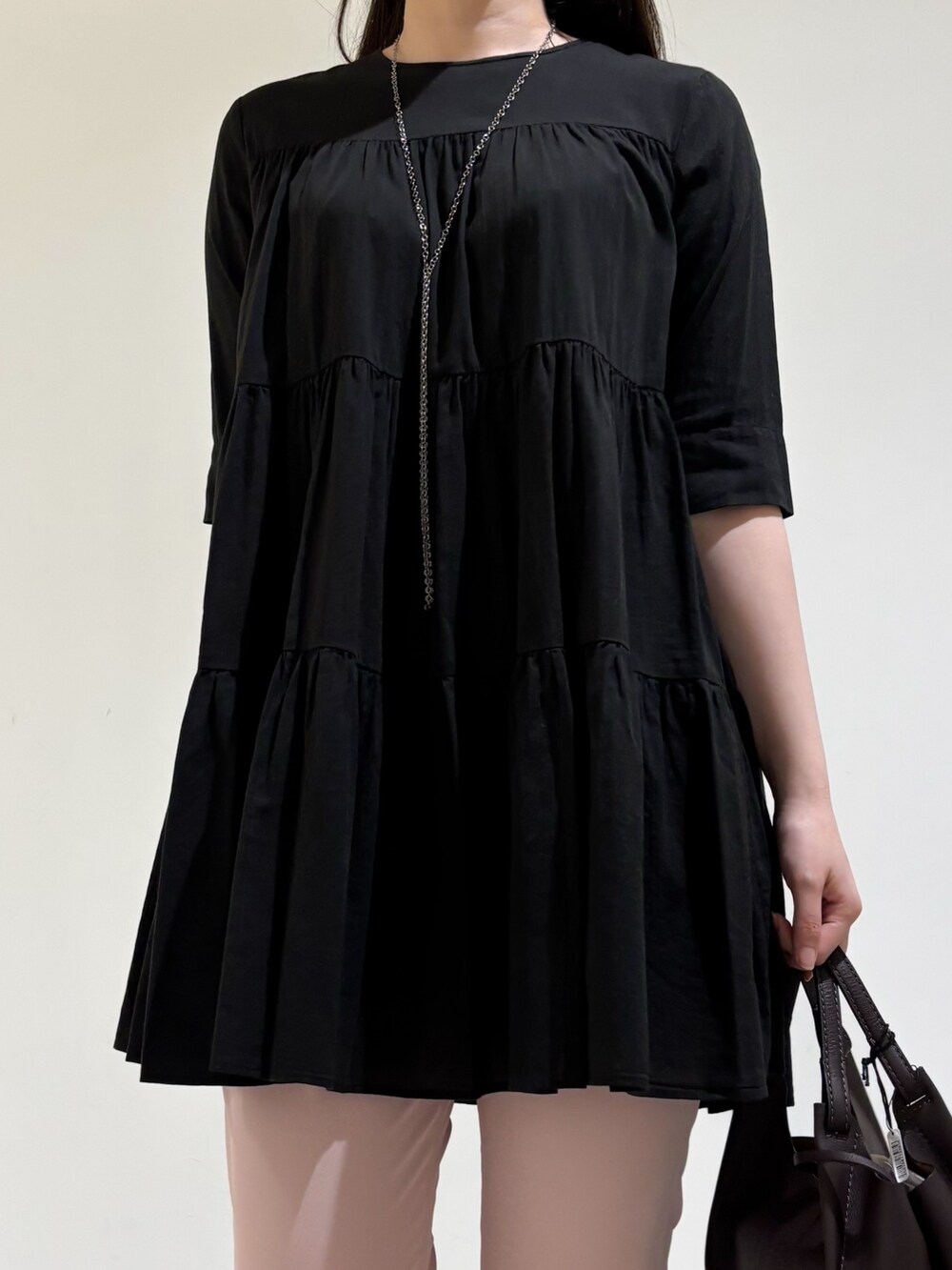 ブラック系のシャツ/ブラウス、ピンク系のスラックス、ブラック系のサンダルを着用したレディースの秋コーディネートの5枚目の写真