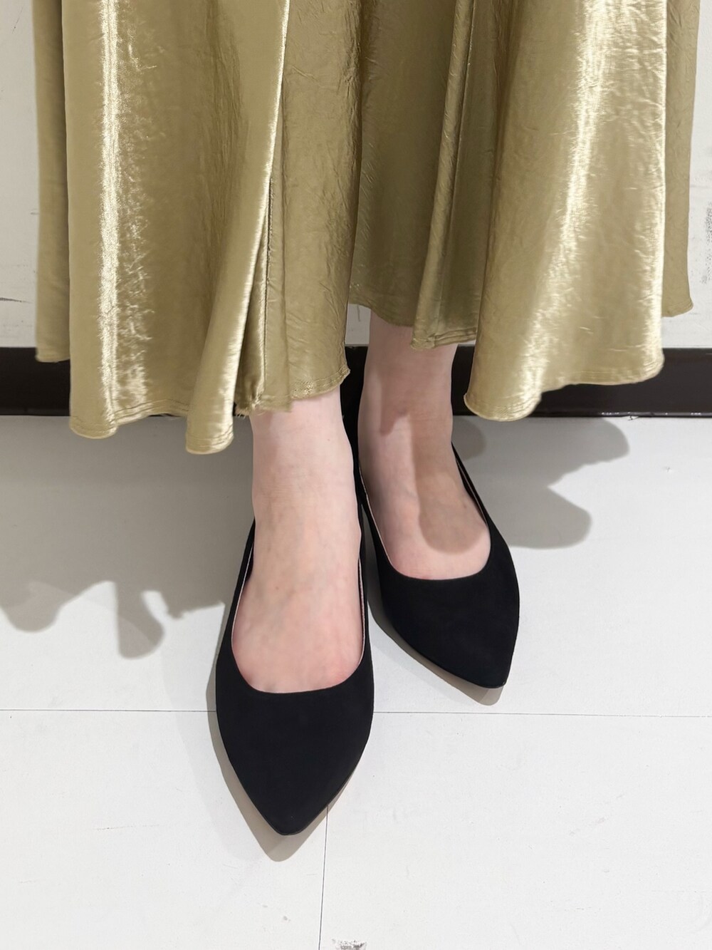 ベージュ系のショルダーバッグ、ホワイト系のトートバッグ、ブラック系のパンプスを着用したレディースの冬コーディネートの2枚目の写真