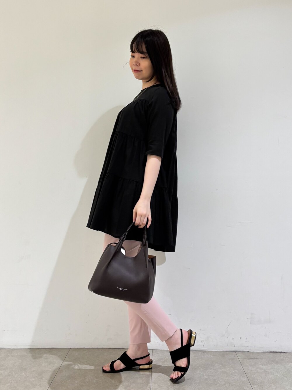 ブラック系のシャツ/ブラウス、ピンク系のスラックス、ブラック系のサンダルを着用したレディースの秋コーディネートの4枚目の写真