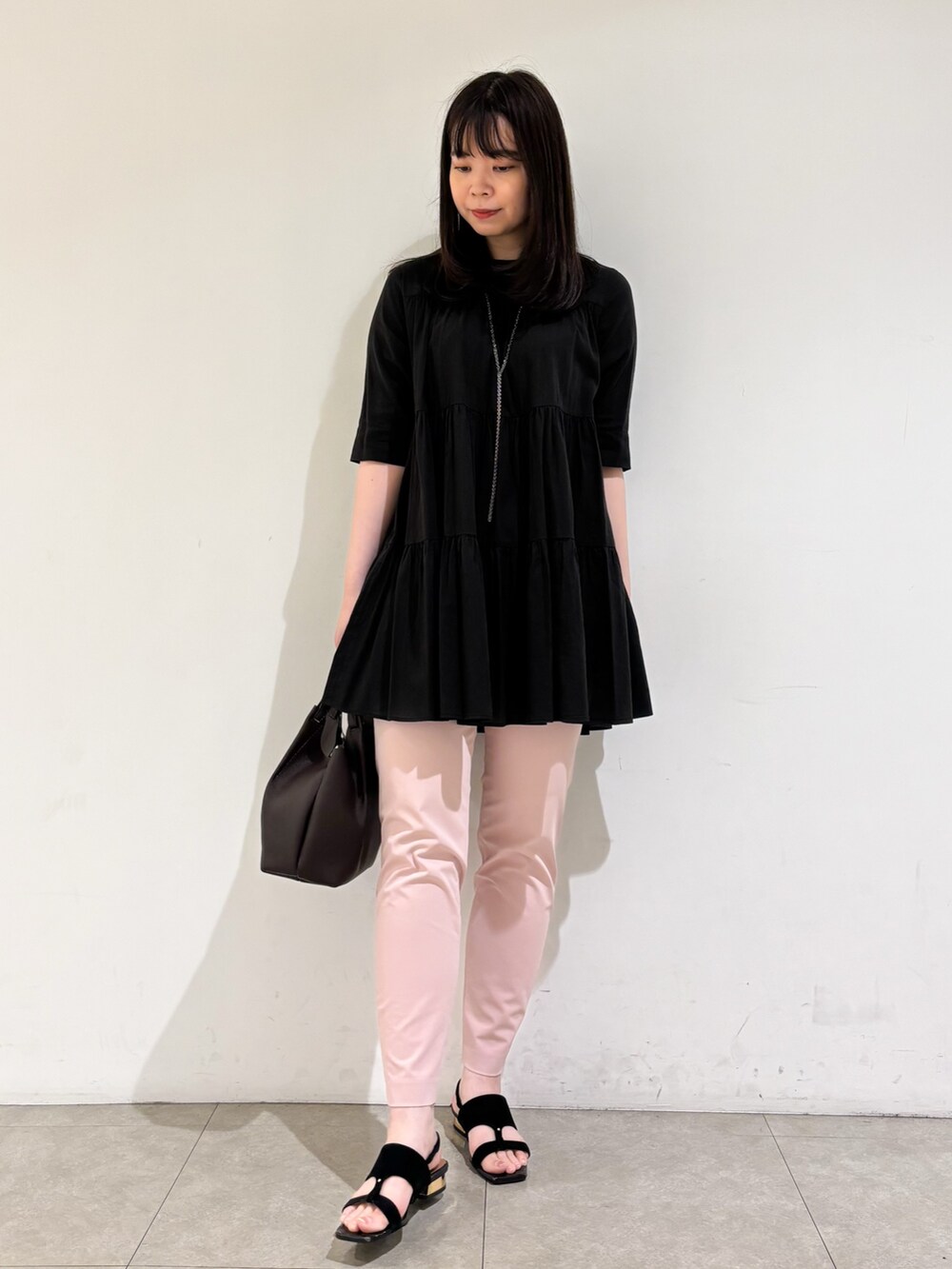 ブラック系のシャツ/ブラウス、ピンク系のスラックス、ブラック系のサンダルを着用したレディースの秋コーディネートの2枚目の写真