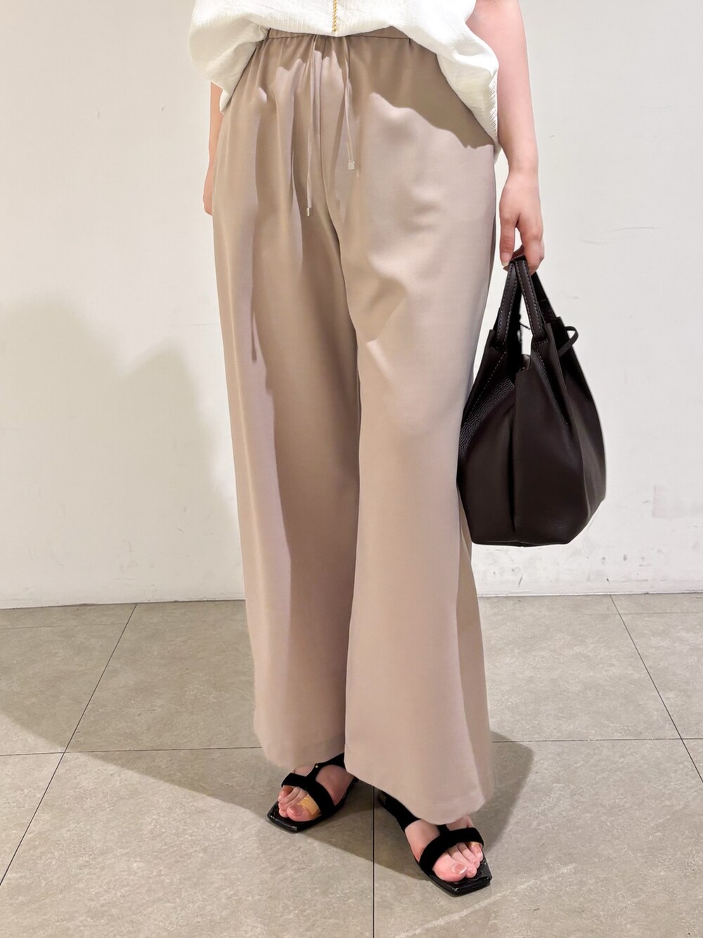 ホワイト系のTシャツ/カットソー、ベージュ系のその他パンツ、ブラック系のサンダルを着用したレディースの夏コーディネートの8枚目の写真