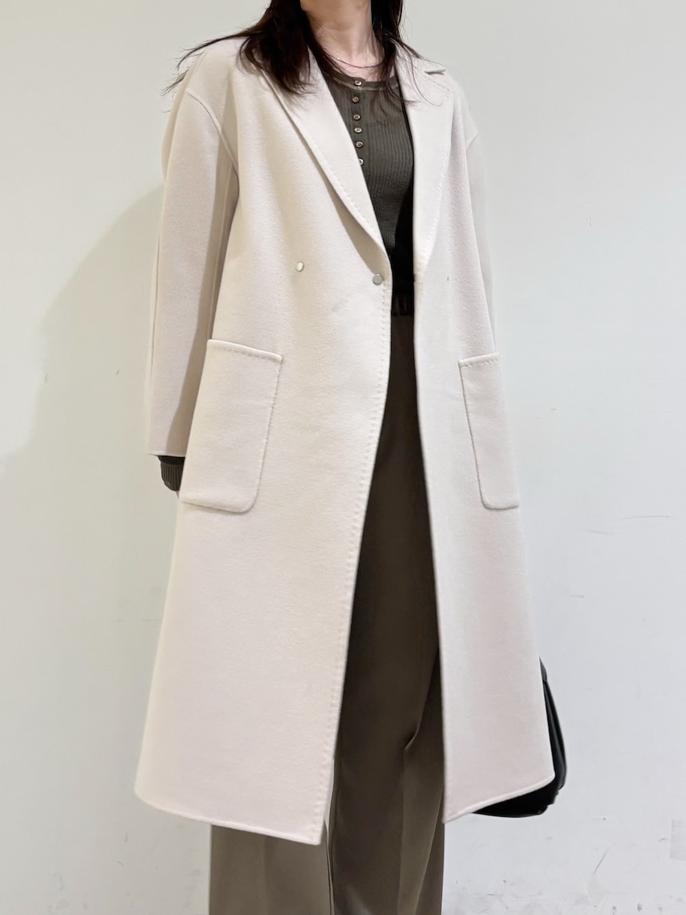 ベージュ系のチェスターコート、ブラウン系のニット/セーター、グリーン系のその他パンツを着用したレディースの秋コーディネートの7枚目の写真