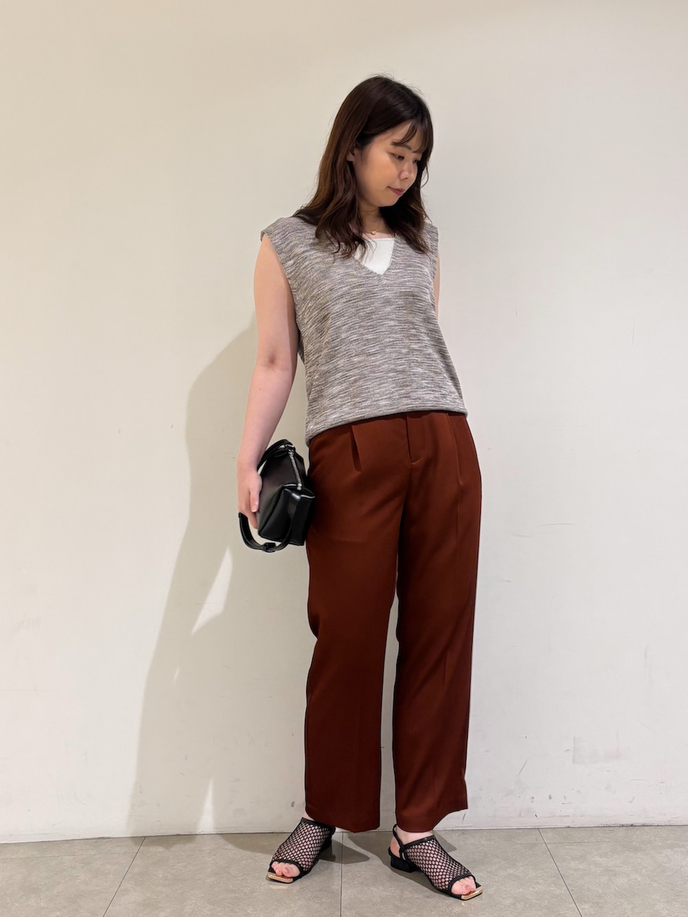 ピンク系のベスト、ブラウン系のその他パンツ、ブラック系のサンダルを着用したレディースの秋コーディネートの3枚目の写真