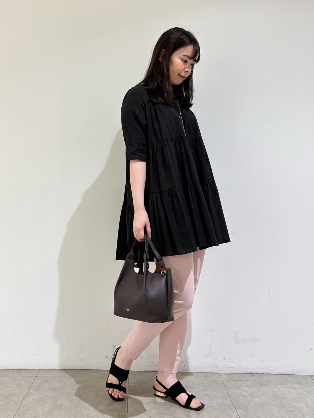 ブラック系のシャツ/ブラウス、ピンク系のスラックス、ブラック系のサンダルを着用したレディースの秋コーディネートの3枚目の写真