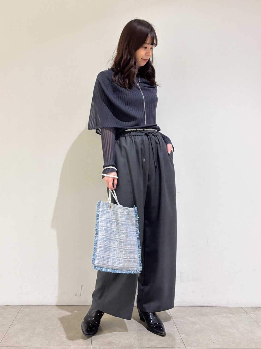 グレー系のニット/セーター、グレー系のその他パンツ、シルバー系のトートバッグを着用したレディースの秋コーディネートの3枚目の写真