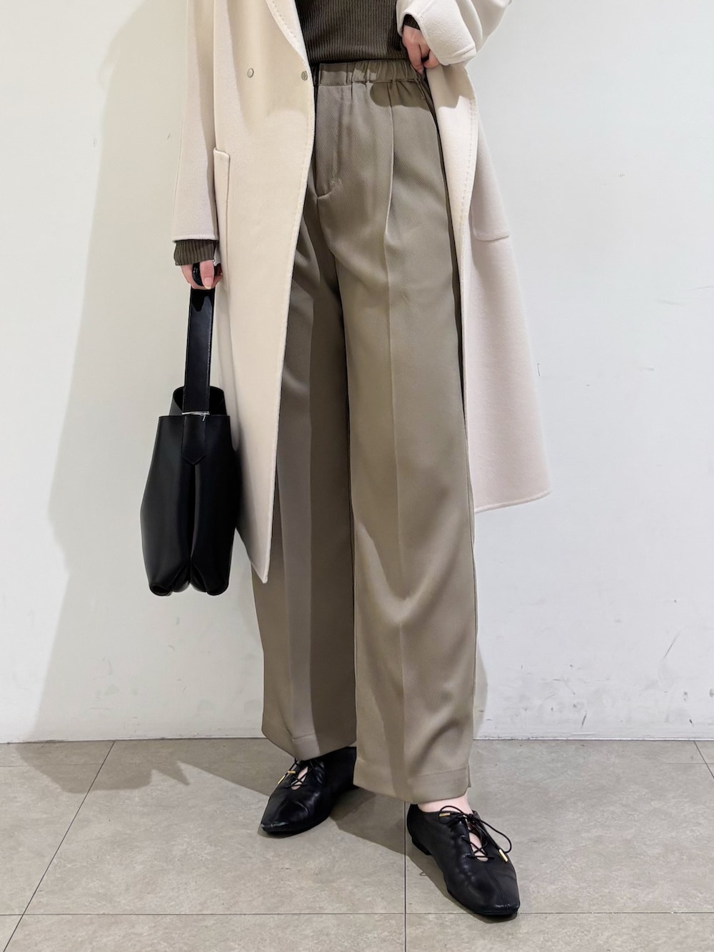 ベージュ系のチェスターコート、ブラウン系のニット/セーター、グリーン系のその他パンツを着用したレディースの秋コーディネートの9枚目の写真