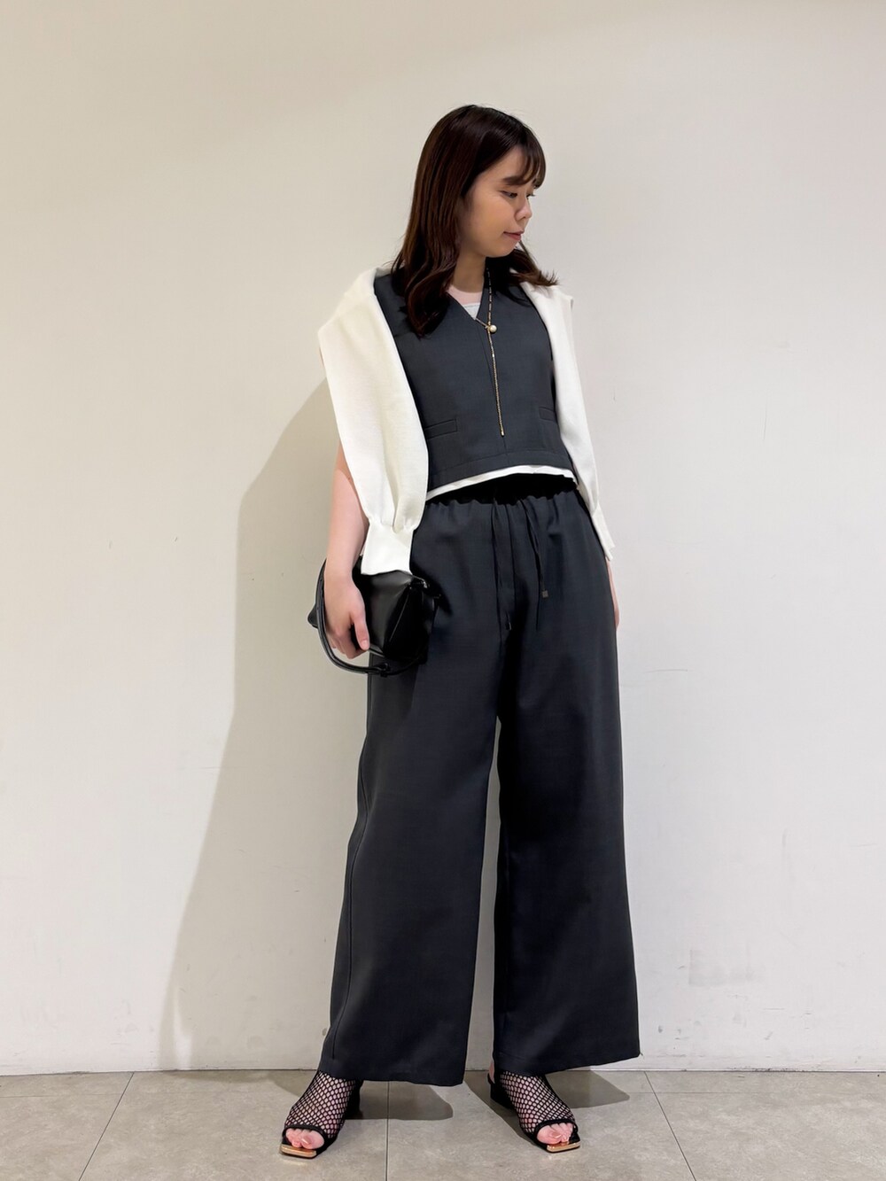 グレー系のその他パンツ、ブラック系のサンダル、グレー系のタンクトップを着用したレディースの夏コーディネートの2枚目の写真