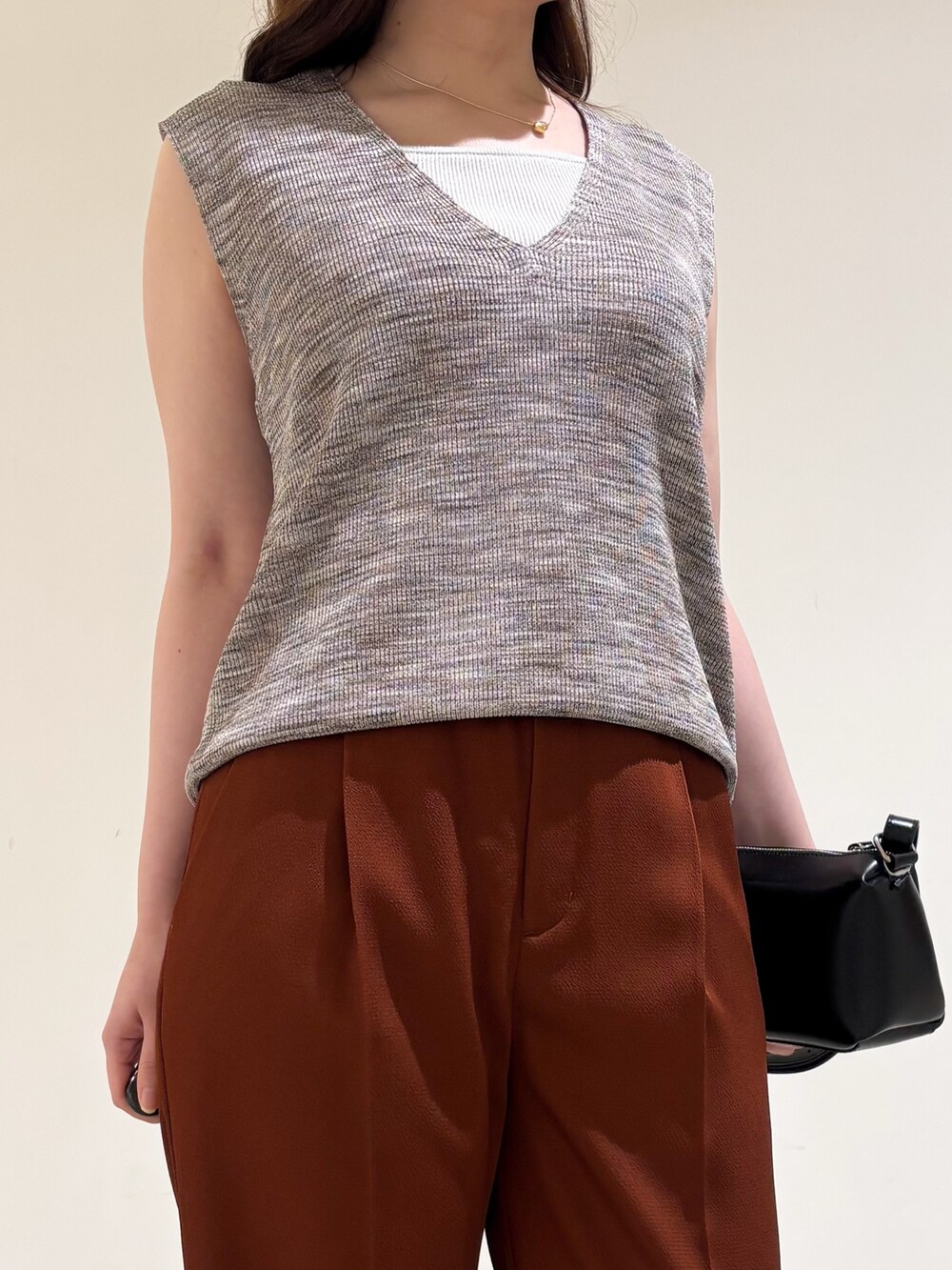 ピンク系のベスト、ブラウン系のその他パンツ、ブラック系のサンダルを着用したレディースの秋コーディネートの5枚目の写真