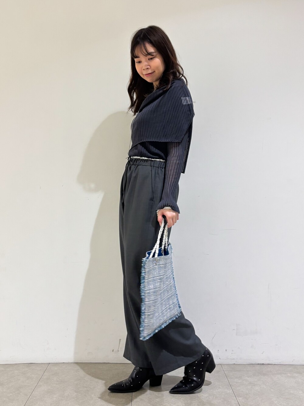 グレー系のニット/セーター、グレー系のその他パンツ、シルバー系のトートバッグを着用したレディースの秋コーディネートの5枚目の写真