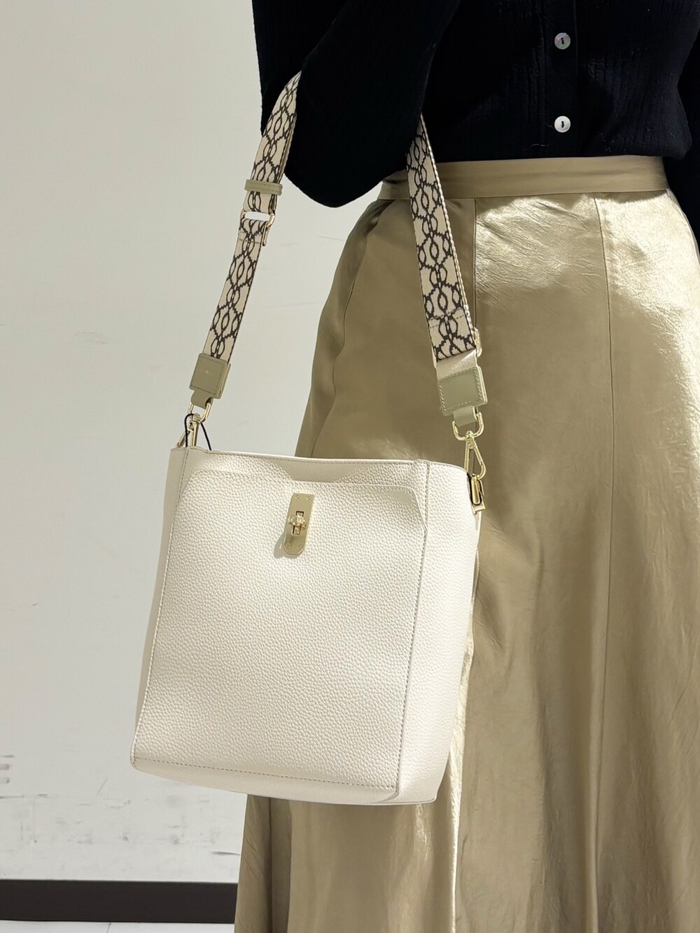 ベージュ系のショルダーバッグ、ホワイト系のトートバッグ、ブラック系のパンプスを着用したレディースの冬コーディネートの7枚目の写真