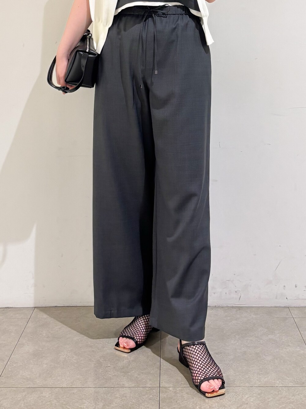 グレー系のその他パンツ、ブラック系のサンダル、グレー系のタンクトップを着用したレディースの夏コーディネートの9枚目の写真