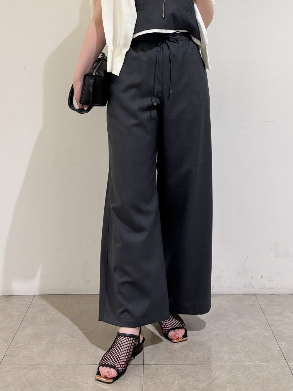 グレー系のその他パンツ、ブラック系のサンダル、グレー系のタンクトップを着用したレディースの夏コーディネートの8枚目の写真