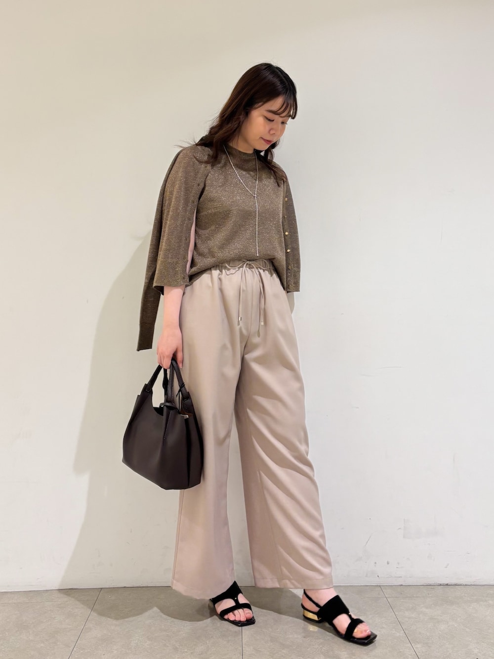 ブラウン系のカーディガン/ボレロ、ブラウン系のタンクトップ、ベージュ系のその他パンツを着用したレディースの夏コーディネートの2枚目の写真