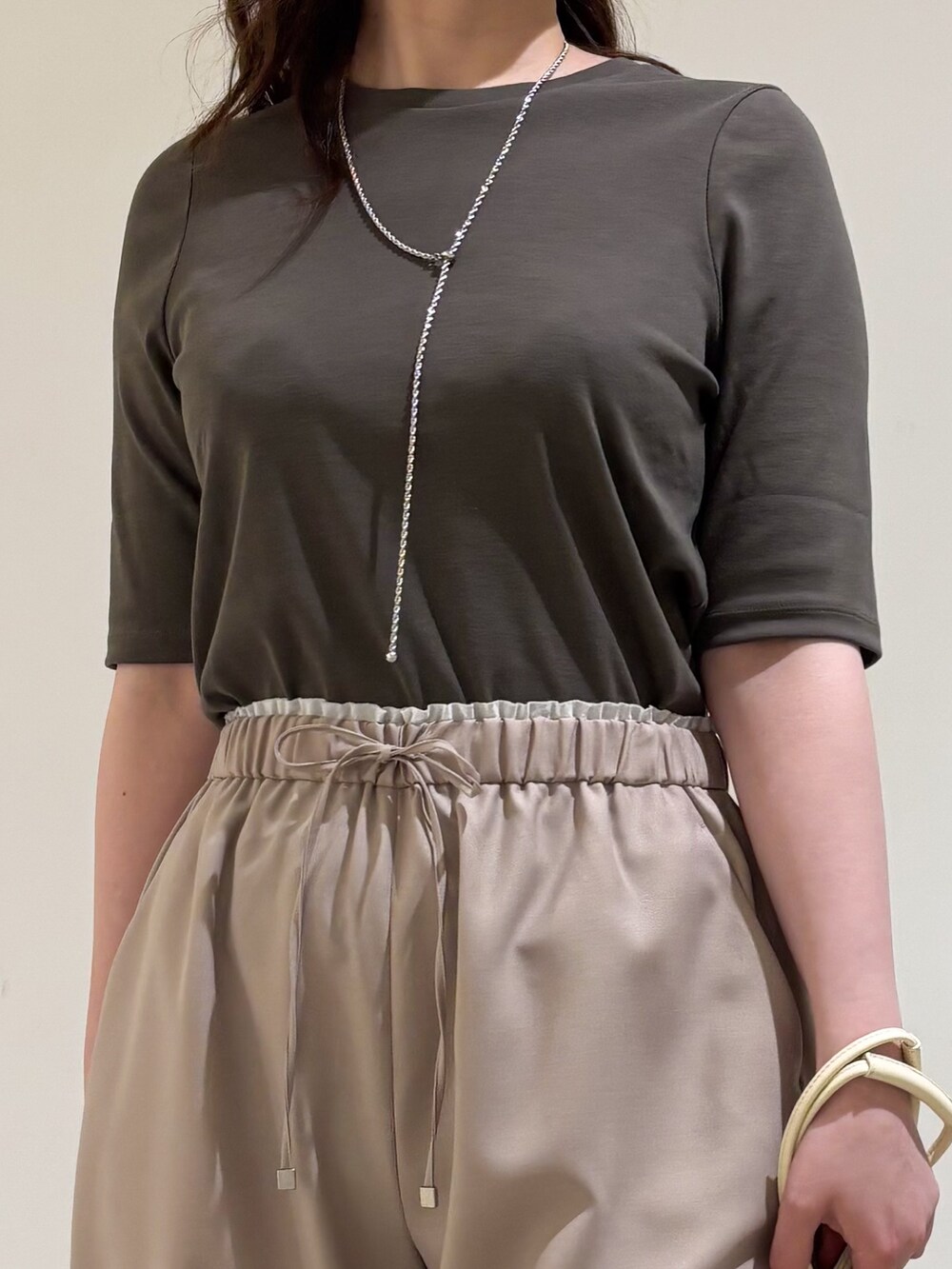 ベージュ系のその他パンツ、ホワイト系のショルダーバッグ、ブラック系のサンダルを着用したレディースの夏コーディネートの7枚目の写真