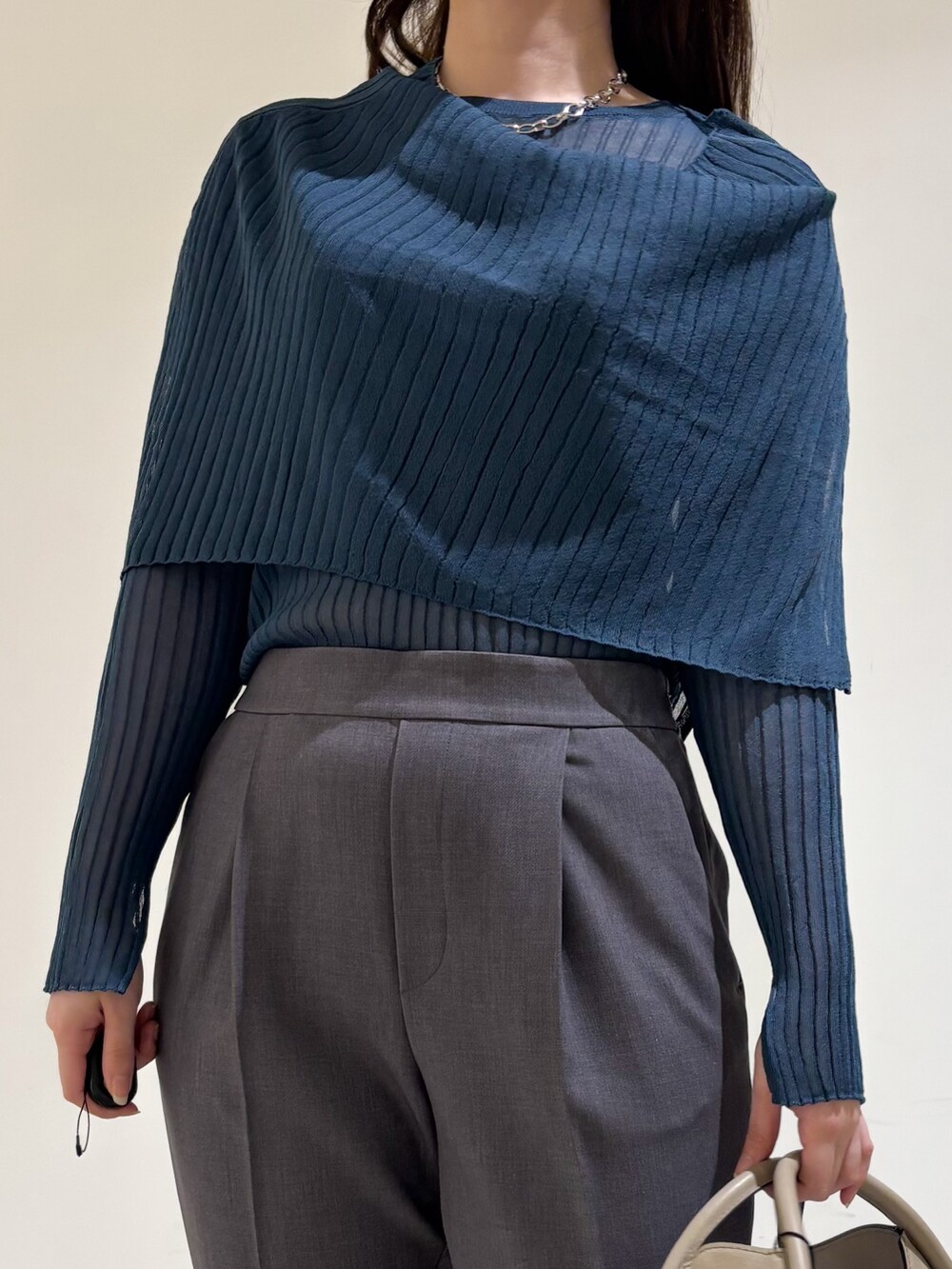 ブルー系のニット/セーター、グレー系のスラックスを着用したレディースの秋コーディネートの7枚目の写真