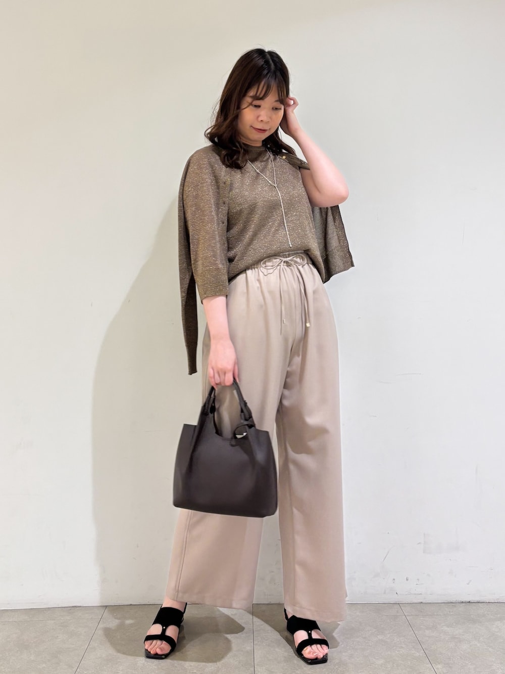 ブラウン系のカーディガン/ボレロ、ブラウン系のタンクトップ、ベージュ系のその他パンツを着用したレディースの夏コーディネートの3枚目の写真