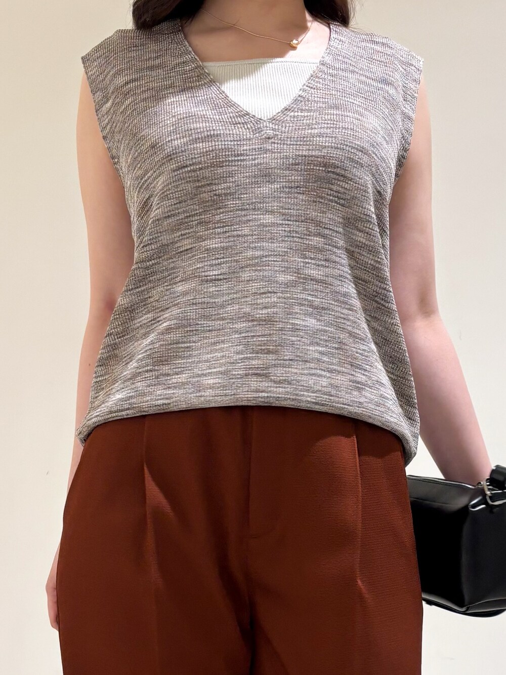 ピンク系のベスト、ブラウン系のその他パンツ、ブラック系のサンダルを着用したレディースの秋コーディネートの6枚目の写真