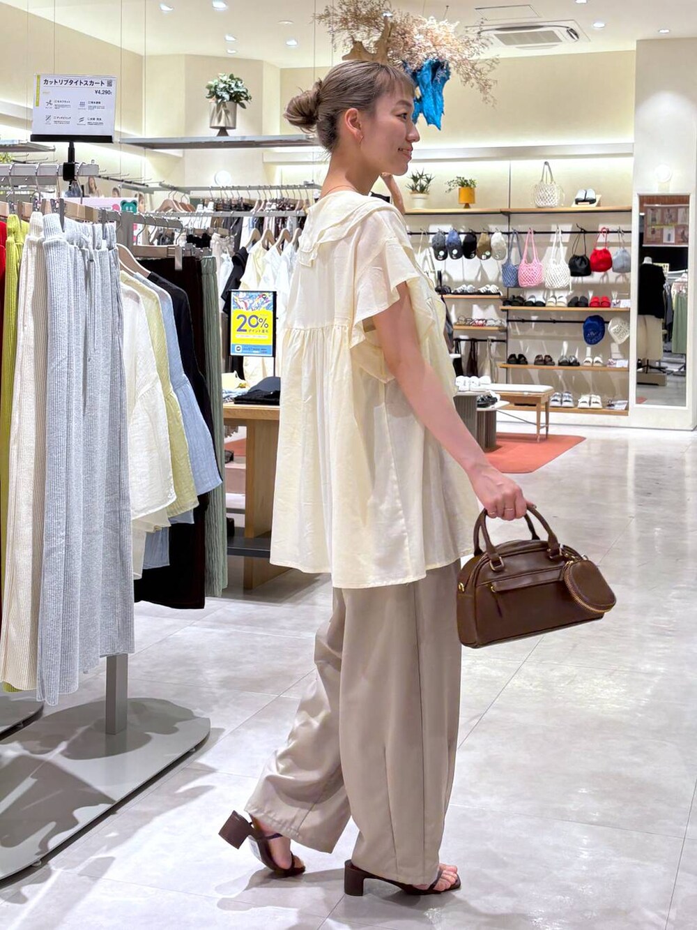 ゴールド系のタンクトップ、ブラウン系のサンダル、ベージュ系のその他パンツを着用したレディースの夏コーディネートの3枚目の写真