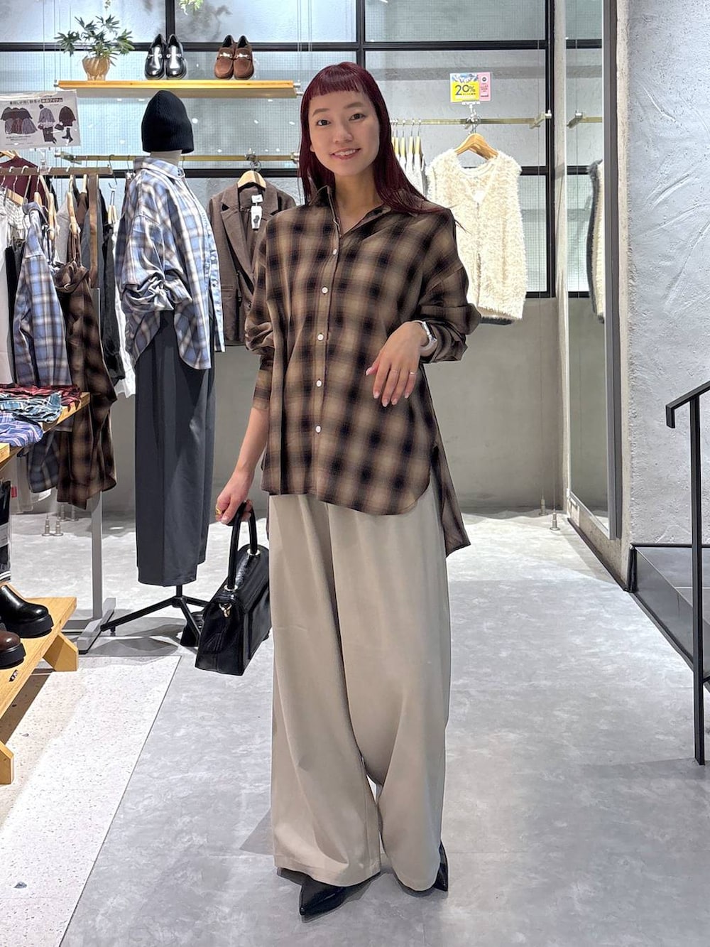 ベージュ系のその他パンツ、ブラウン系のシャツ/ブラウス、ブラック系のボストンバッグを着用したレディースの秋コーディネートの2枚目の写真