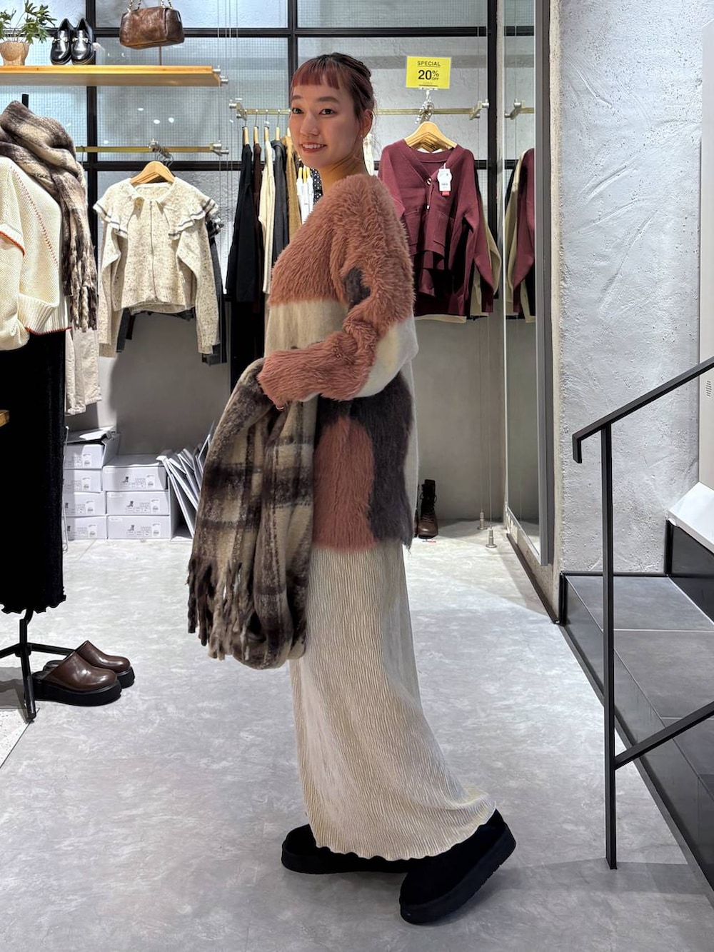 ピンク系のカーディガン/ボレロ、ゴールド系のタンクトップ、ホワイト系のスカートを着用したレディースの秋コーディネートの4枚目の写真