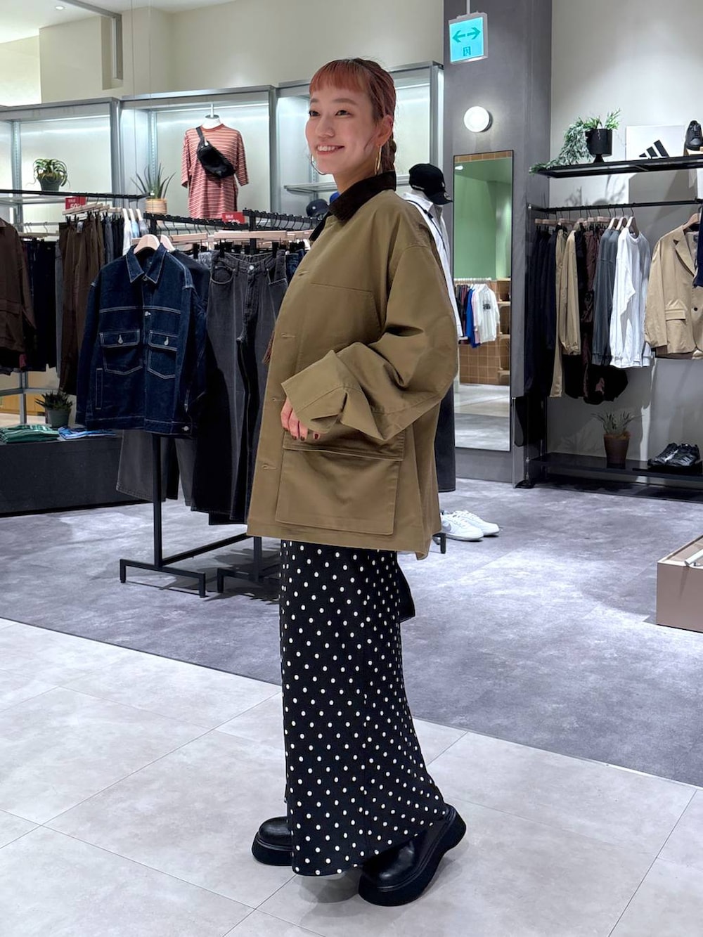 ブラック系のスカート、ブラウン系のブルゾン、ブラック系のボストンバッグを着用したレディースの秋コーディネートの4枚目の写真