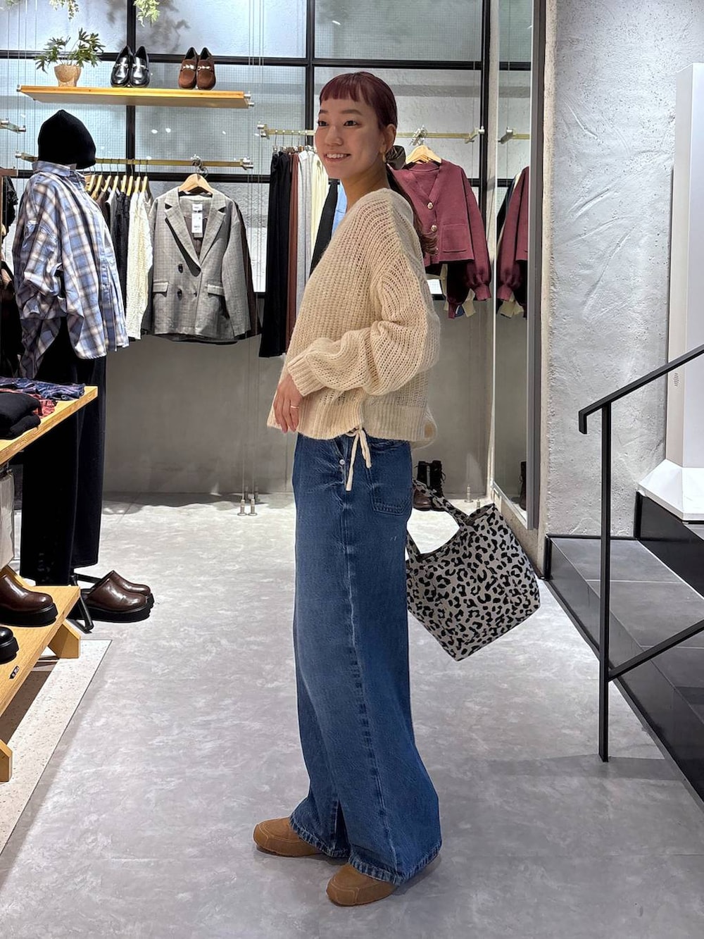 ゴールド系のタンクトップ、その他のショルダーバッグ、ブルー系のデニムパンツを着用したレディースの秋コーディネートの4枚目の写真