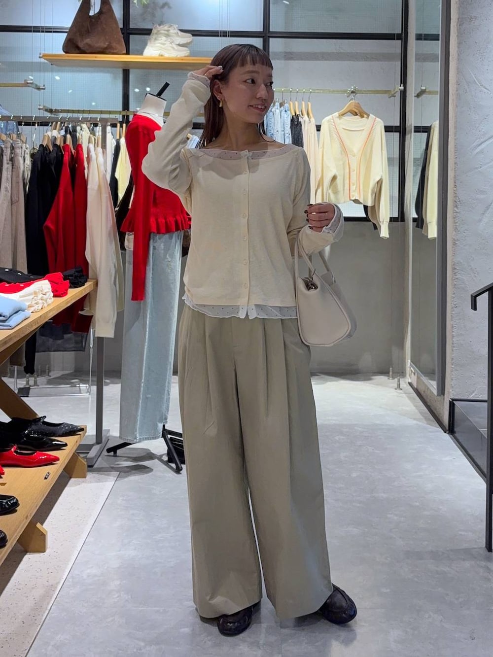 ブラック系のショルダーバッグ、ブラウン系のローファー、ホワイト系のTシャツ/カットソーを着用したレディースの春コーディネートの2枚目の写真