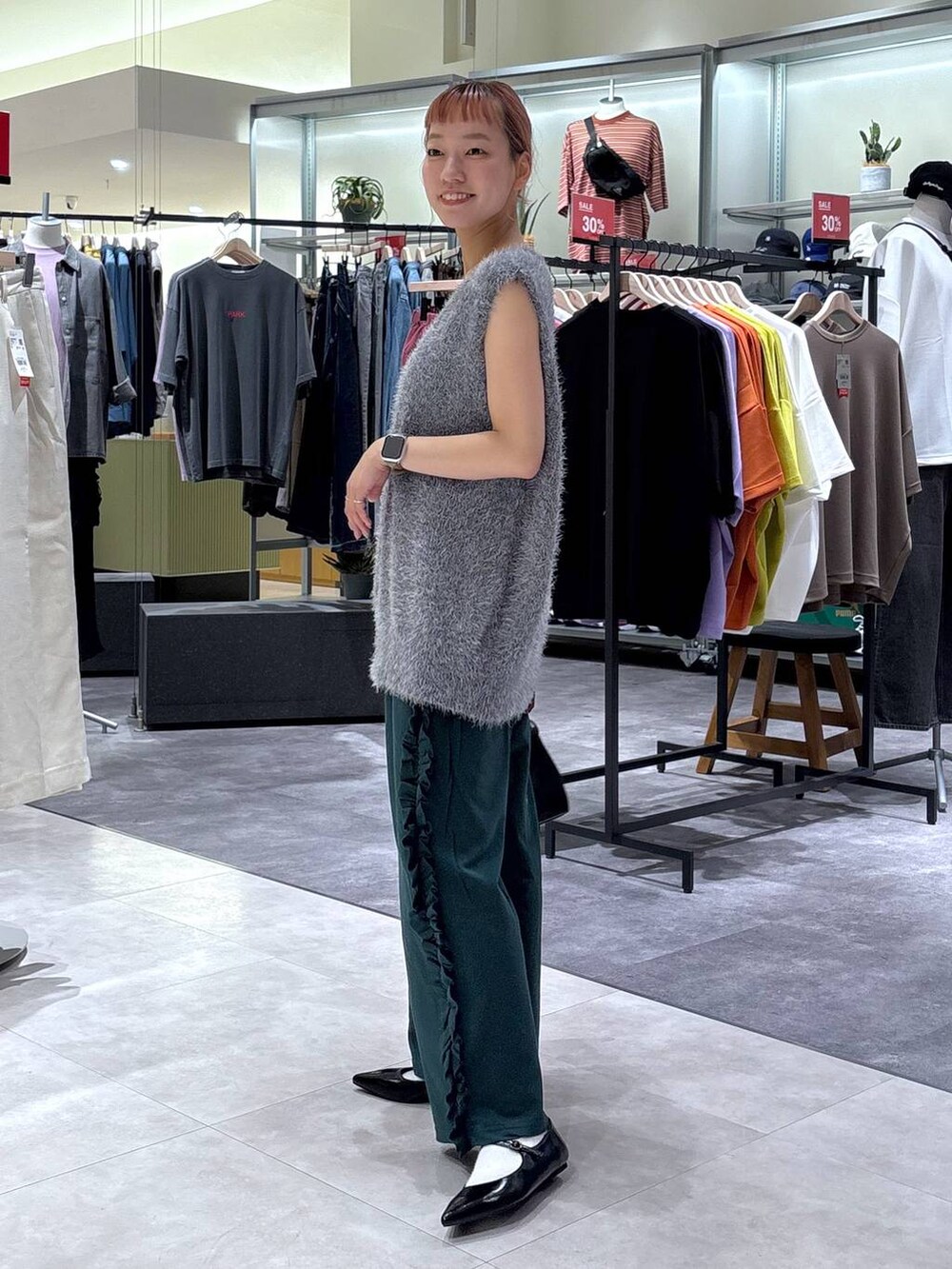 ブラック系のボストンバッグ、グリーン系のスウェットパンツ、グレー系のベストを着用したレディースの秋コーディネートの4枚目の写真