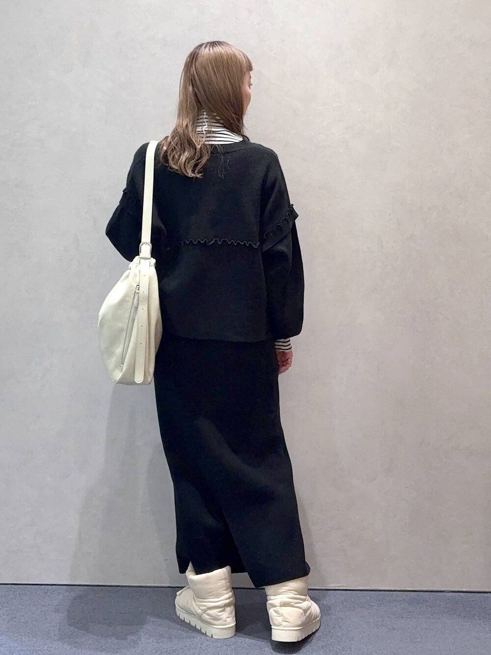 ホワイト系のショルダーバッグ、ブラック系のワンピース、ホワイト系のTシャツ/カットソーを着用したレディースの冬コーディネートの5枚目の写真