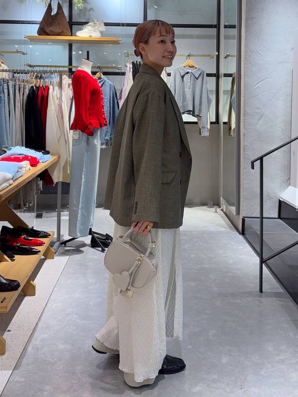 ブラウン系のテーラードジャケット、ホワイト系のボストンバッグ、ブラック系のローファーを着用したレディースの冬コーディネートの3枚目の写真