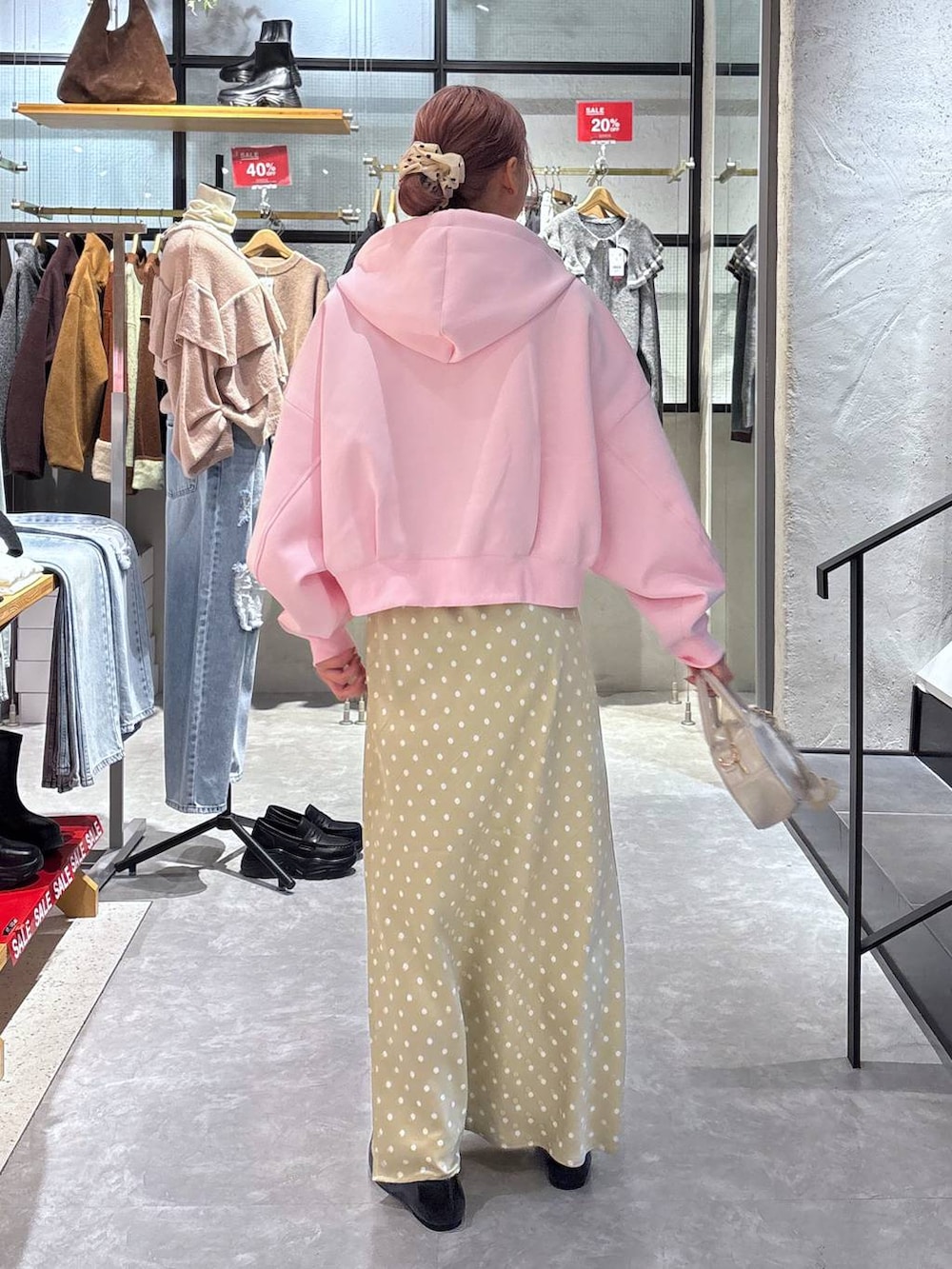 ベージュ系のスカート、ブラック系のパンプス、ピンク系のパーカーを着用したレディースの冬コーディネートの5枚目の写真