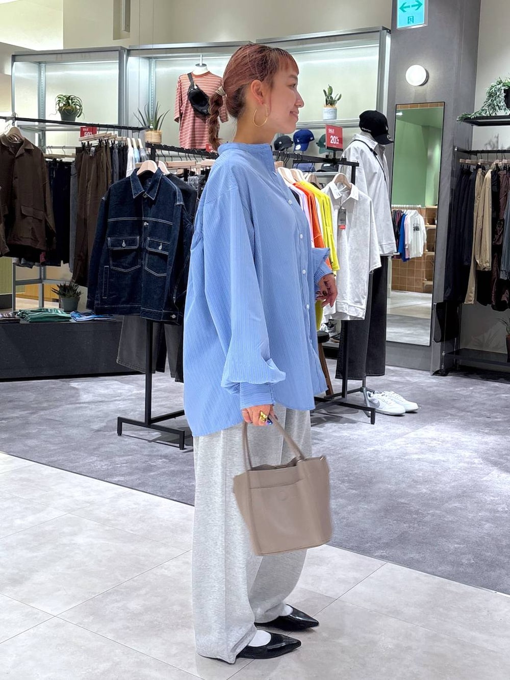 ブルー系のシャツ/ブラウス、グレー系のショルダーバッグ、ブラック系のパンプスを着用したレディースの秋コーディネートの3枚目の写真