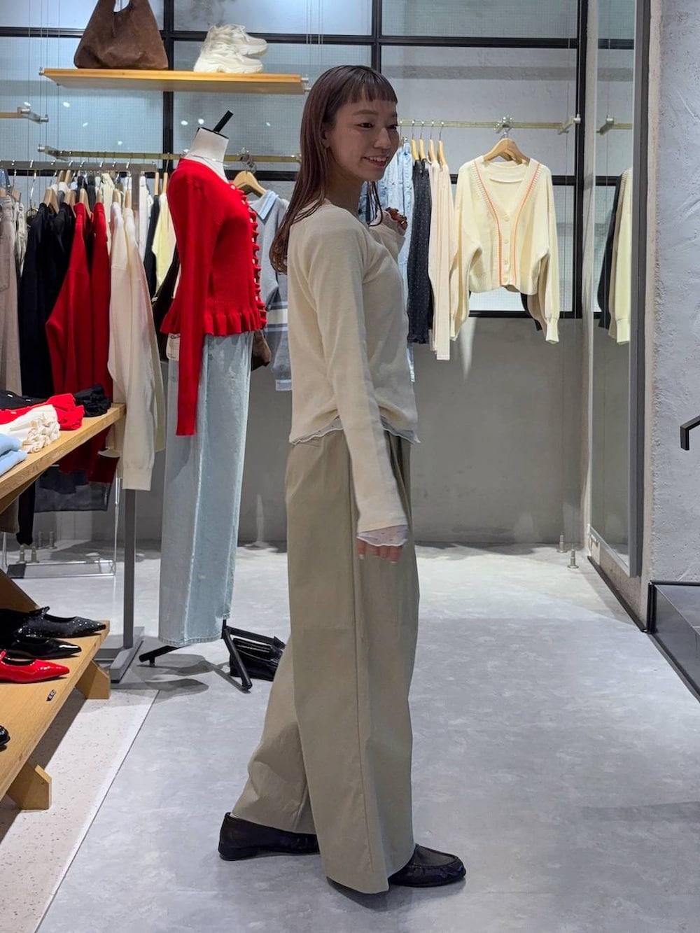 ブラック系のショルダーバッグ、ブラウン系のローファー、ホワイト系のTシャツ/カットソーを着用したレディースの春コーディネートの3枚目の写真