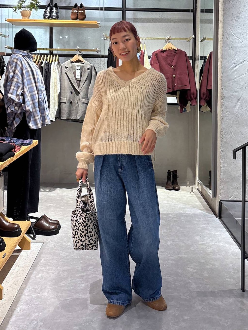 ゴールド系のタンクトップ、その他のショルダーバッグ、ブルー系のデニムパンツを着用したレディースの秋コーディネートの2枚目の写真