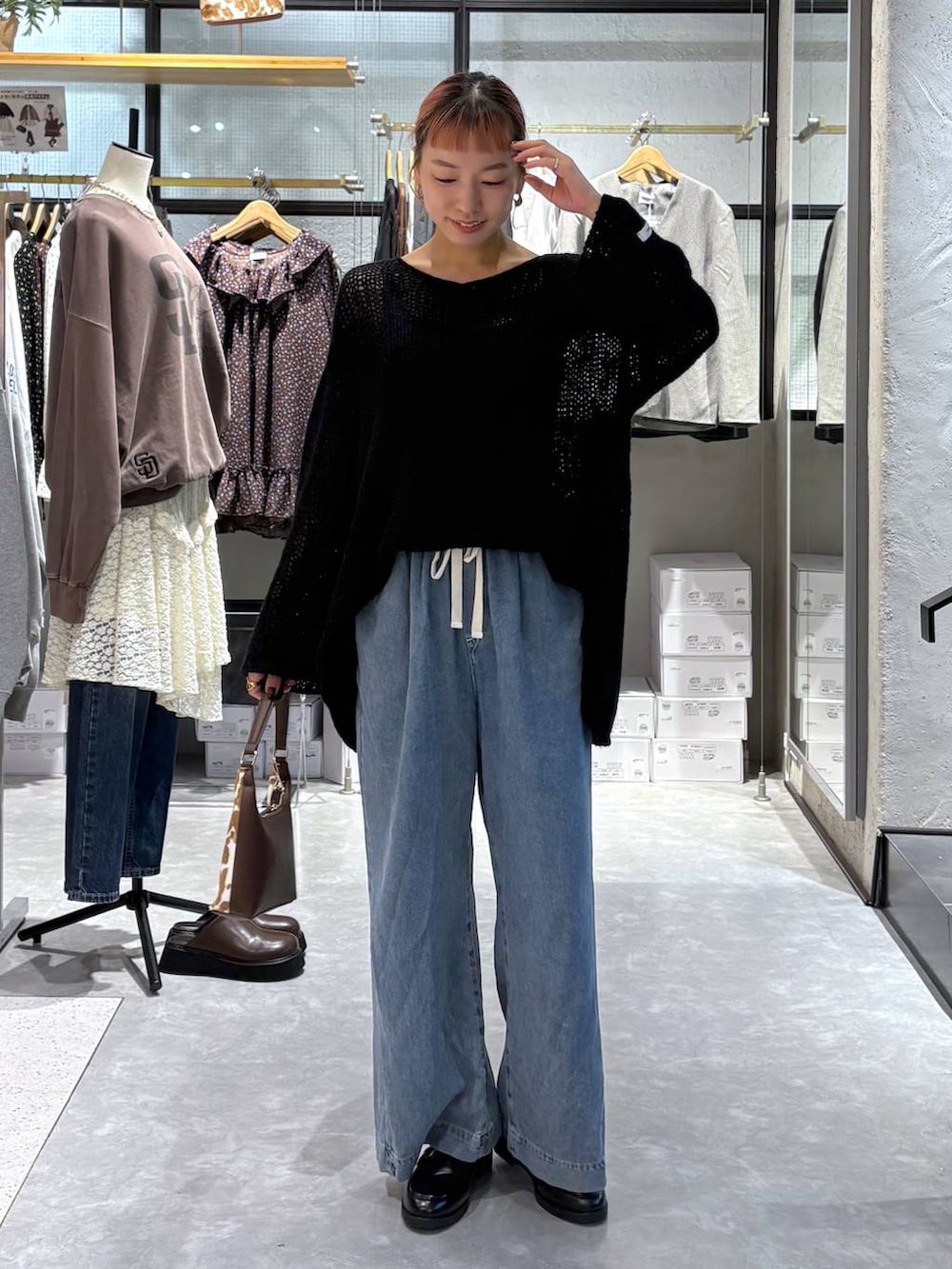 その他のショルダーバッグ、ブラック系のローファー、ブルー系のデニムパンツを着用したレディースの秋コーディネートの2枚目の写真