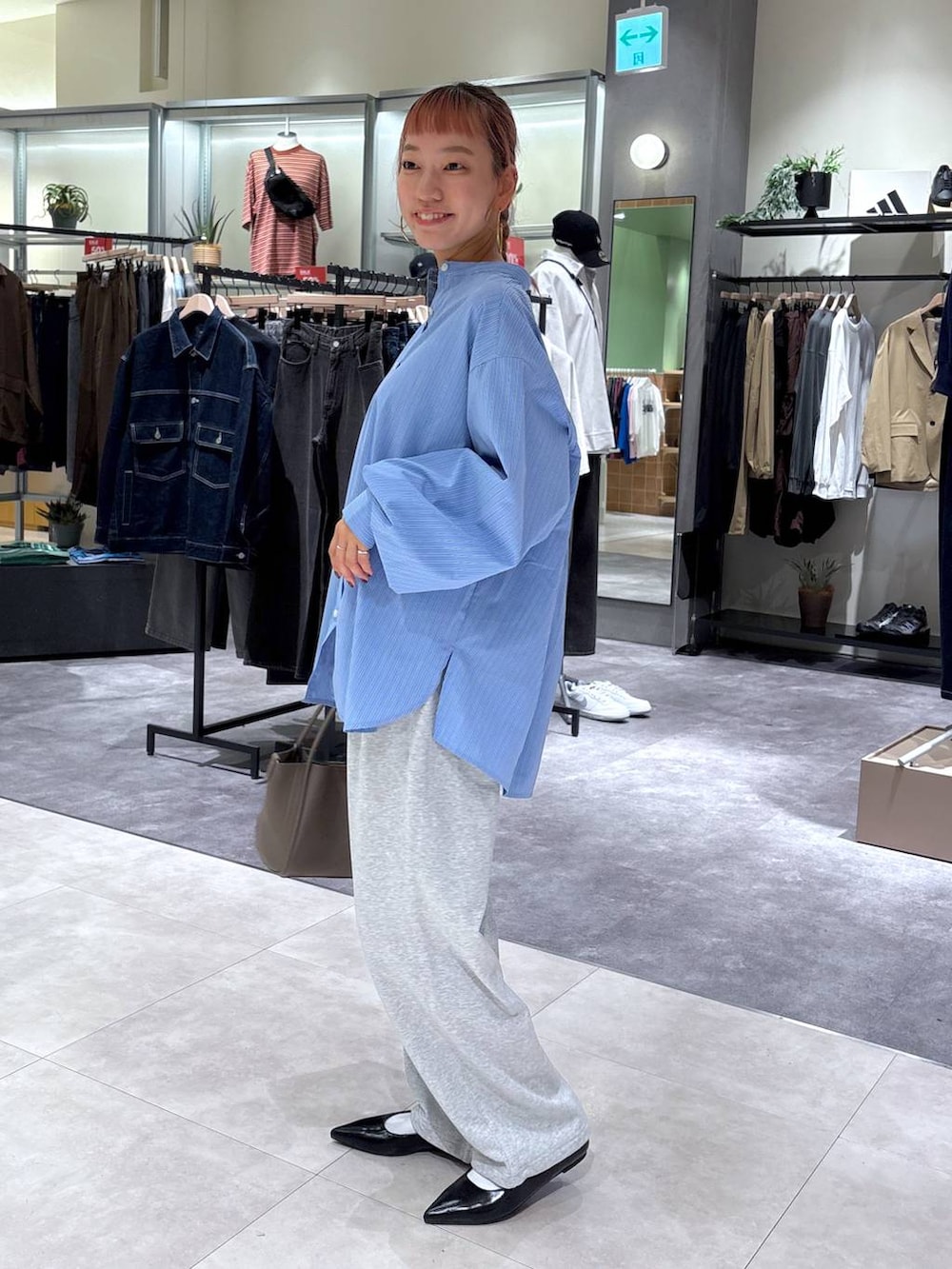 ブルー系のシャツ/ブラウス、グレー系のショルダーバッグ、ブラック系のパンプスを着用したレディースの秋コーディネートの4枚目の写真