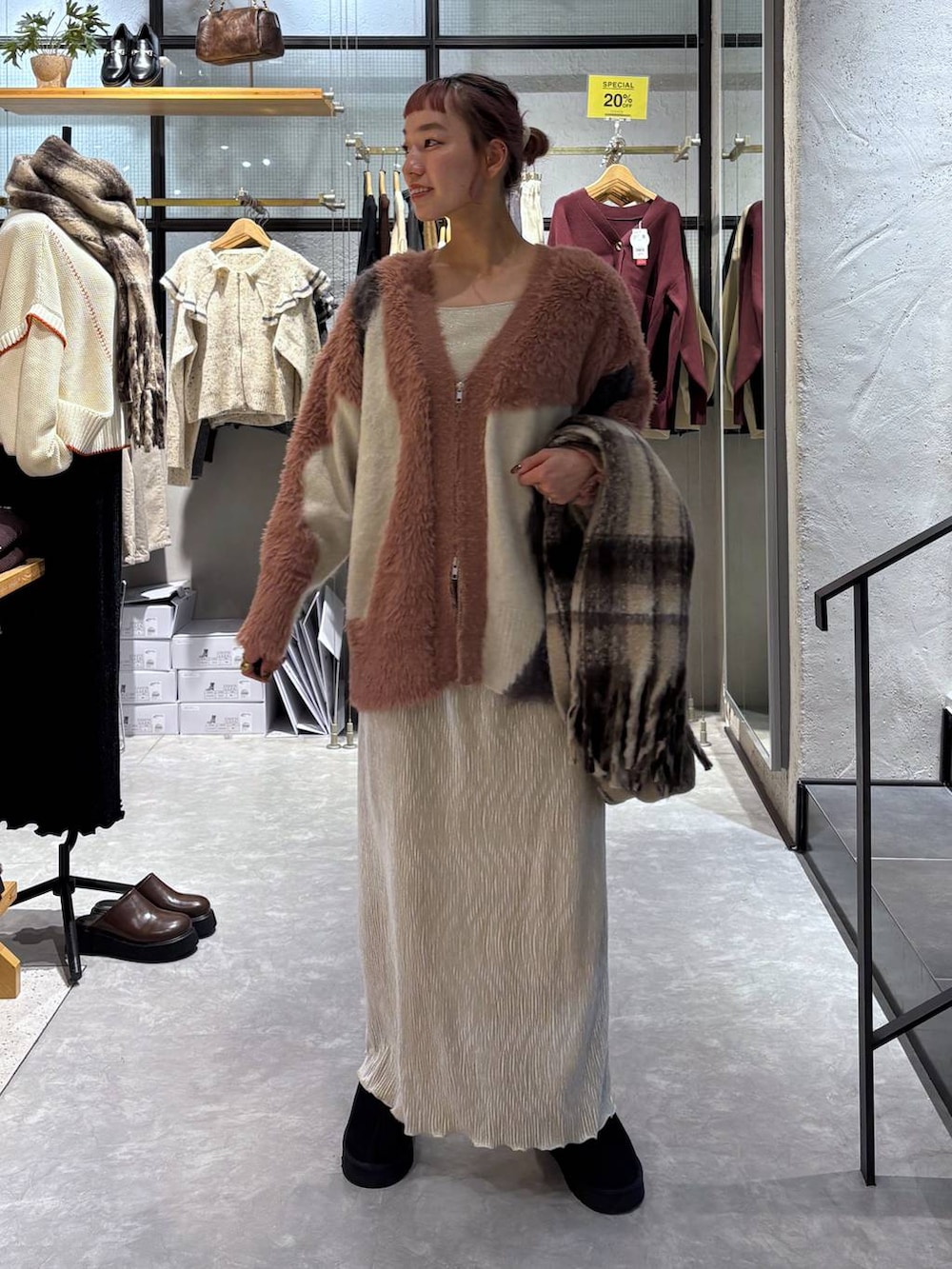 ピンク系のカーディガン/ボレロ、ゴールド系のタンクトップ、ホワイト系のスカートを着用したレディースの秋コーディネートの2枚目の写真