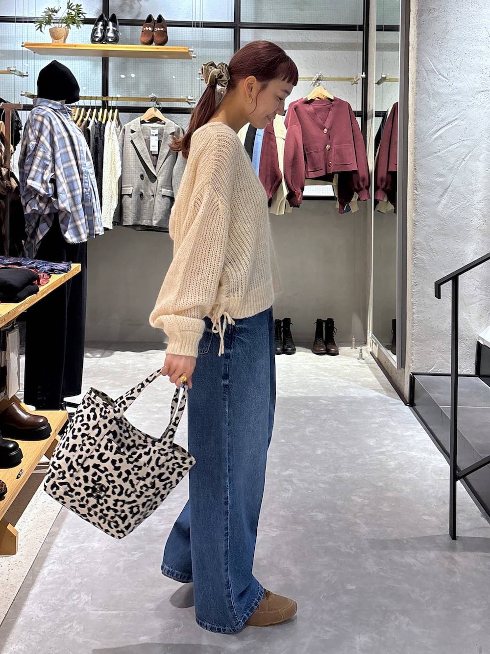 ゴールド系のタンクトップ、その他のショルダーバッグ、ブルー系のデニムパンツを着用したレディースの秋コーディネートの3枚目の写真