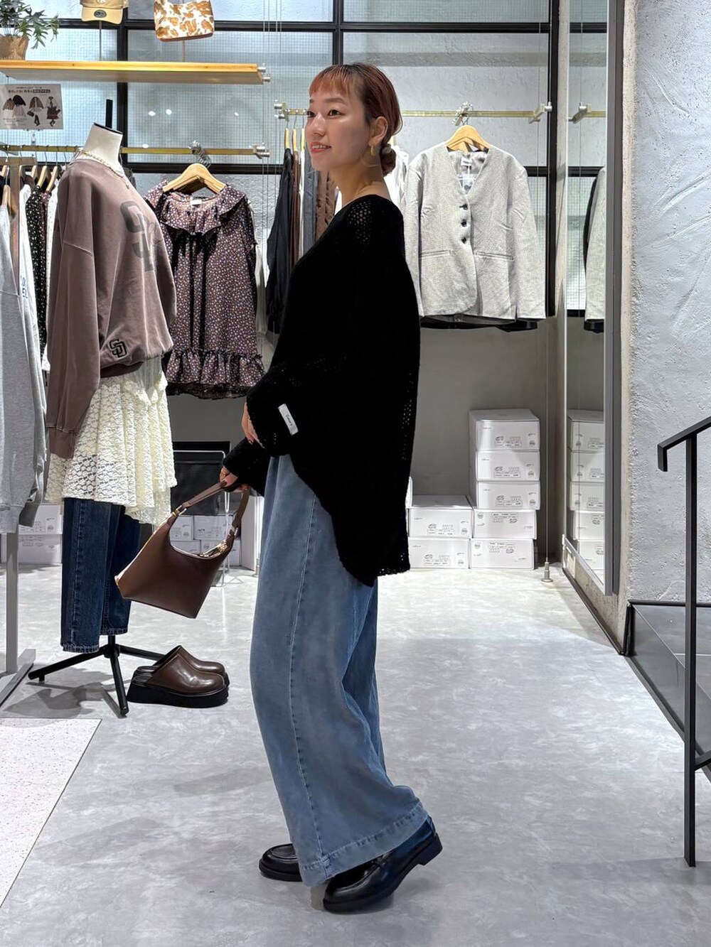 その他のショルダーバッグ、ブラック系のローファー、ブルー系のデニムパンツを着用したレディースの秋コーディネートの4枚目の写真