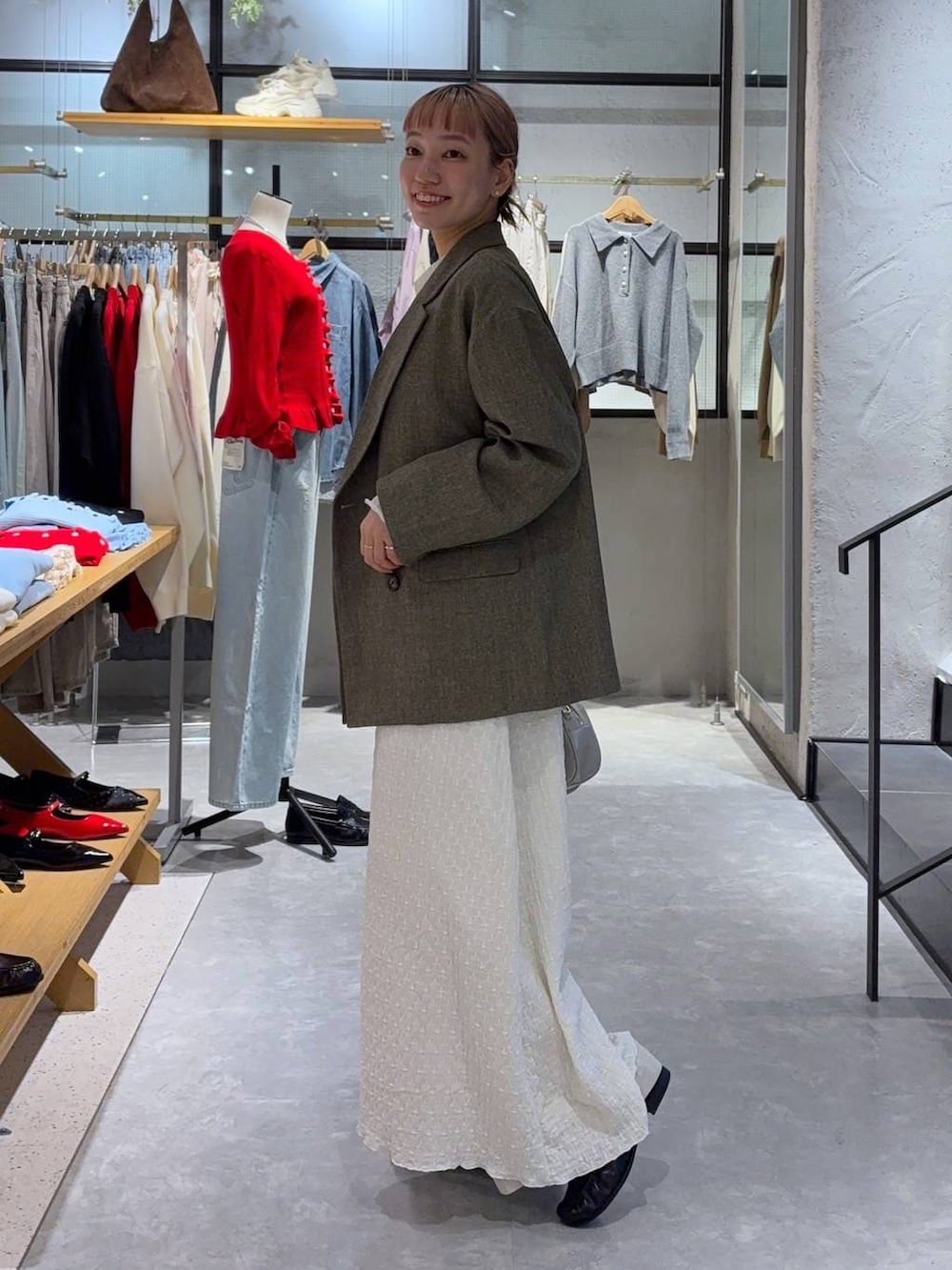 ブラウン系のテーラードジャケット、ホワイト系のボストンバッグ、ブラック系のローファーを着用したレディースの冬コーディネートの4枚目の写真