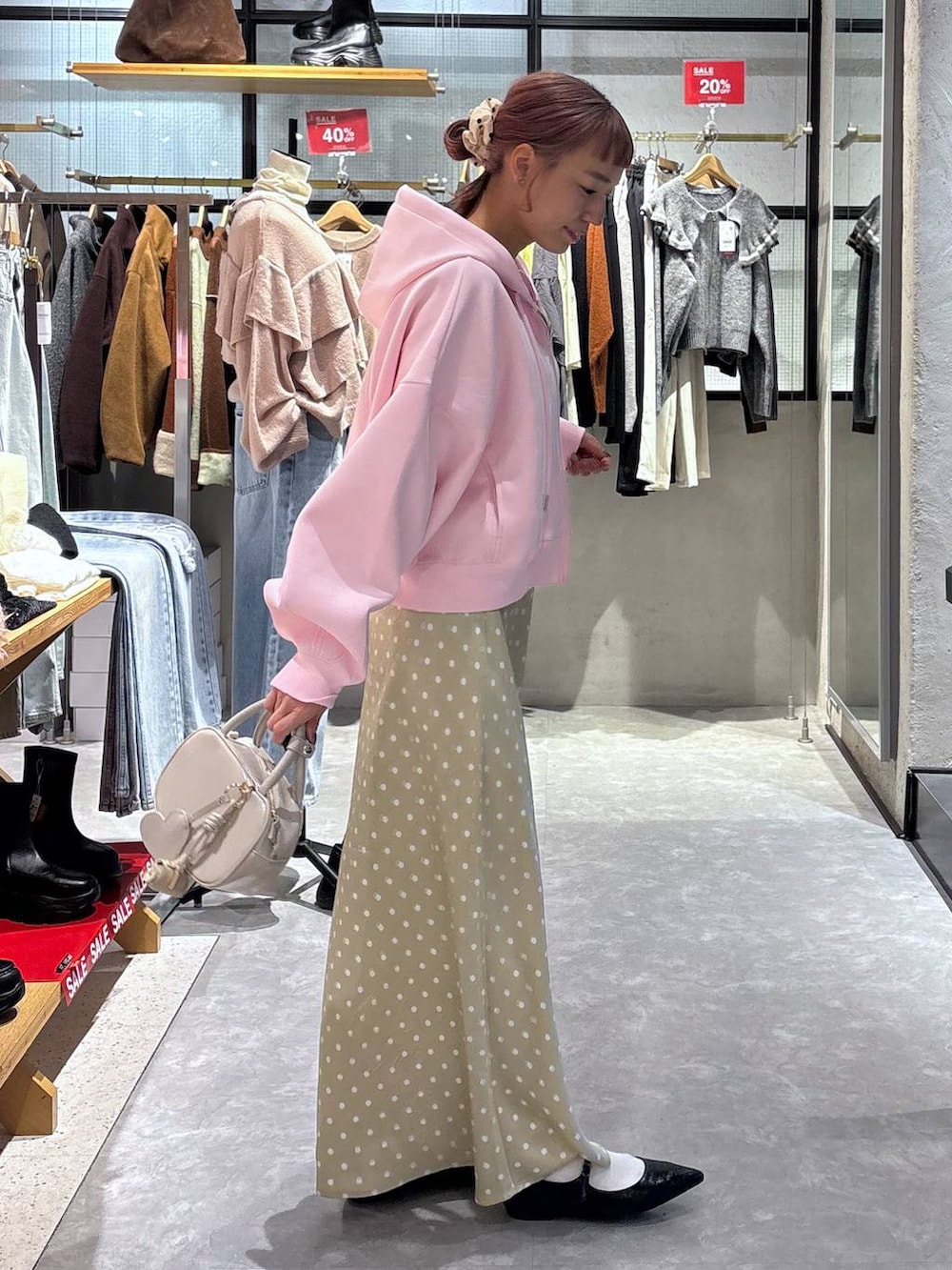 ベージュ系のスカート、ブラック系のパンプス、ピンク系のパーカーを着用したレディースの冬コーディネートの3枚目の写真