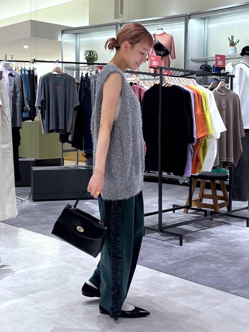 ブラック系のボストンバッグ、グリーン系のスウェットパンツ、グレー系のベストを着用したレディースの秋コーディネートの3枚目の写真