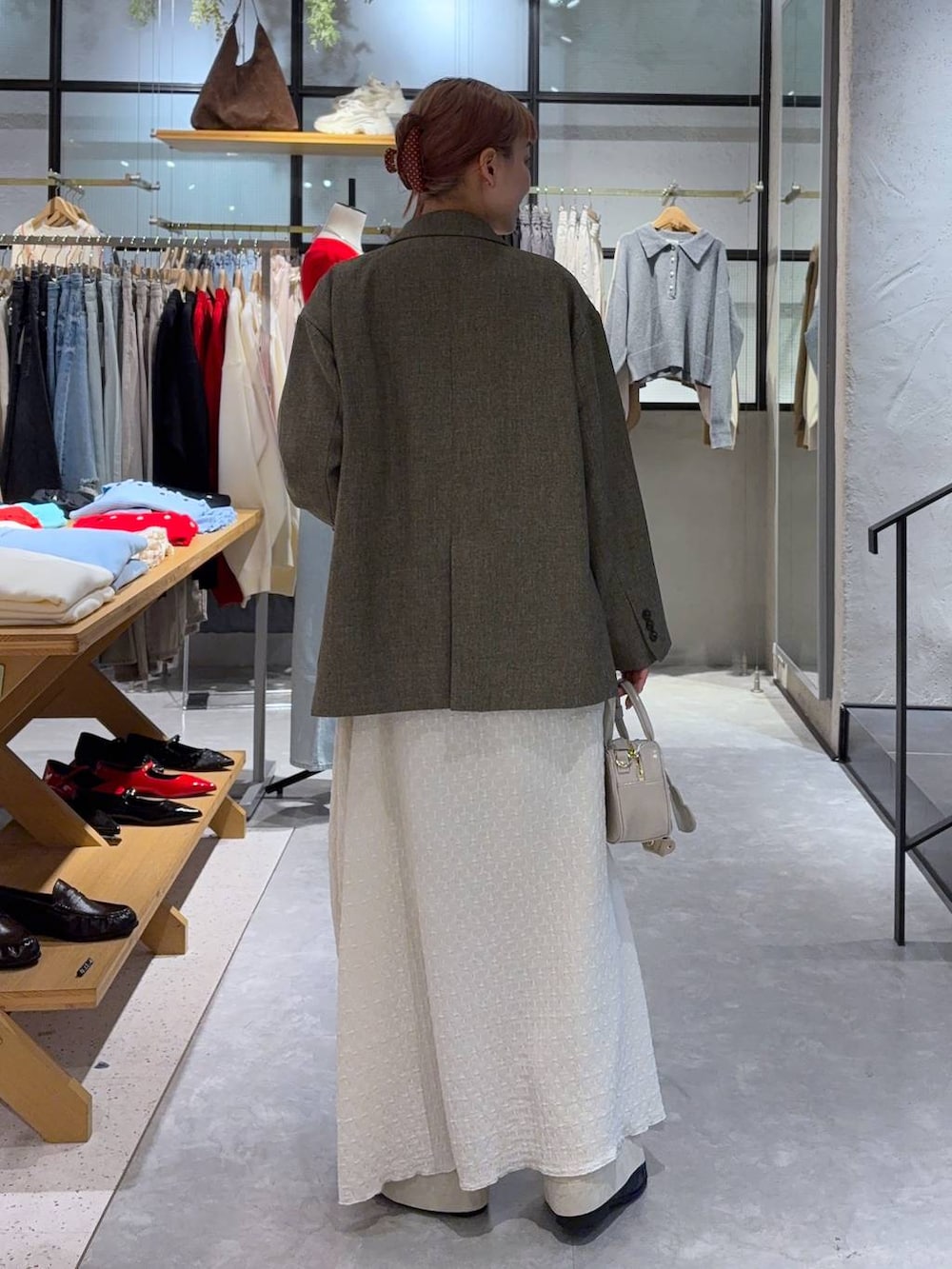 ブラウン系のテーラードジャケット、ホワイト系のボストンバッグ、ブラック系のローファーを着用したレディースの冬コーディネートの5枚目の写真