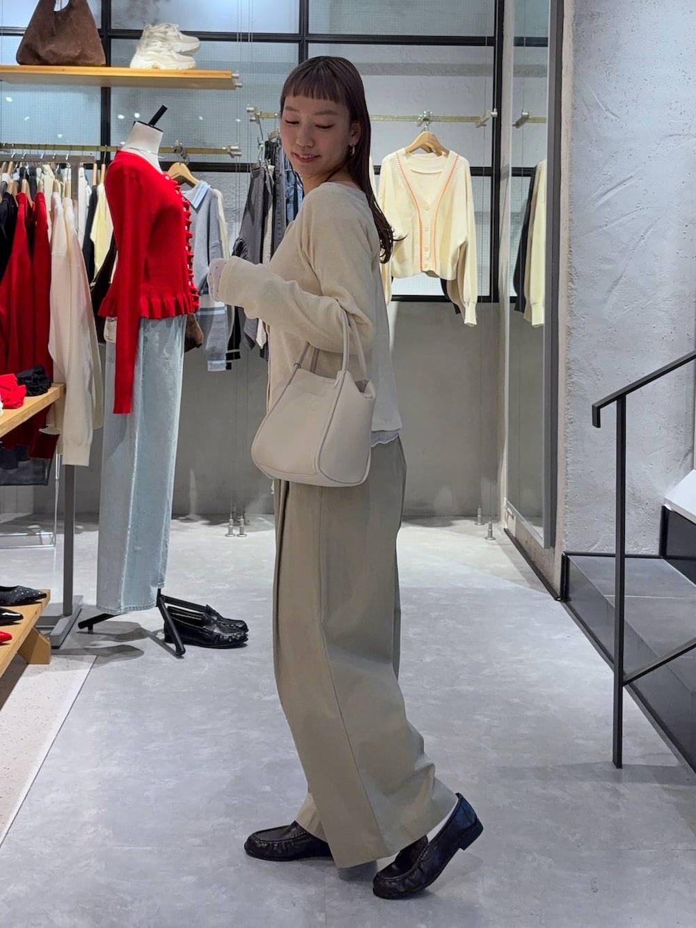 ブラック系のショルダーバッグ、ブラウン系のローファー、ホワイト系のTシャツ/カットソーを着用したレディースの春コーディネートの4枚目の写真