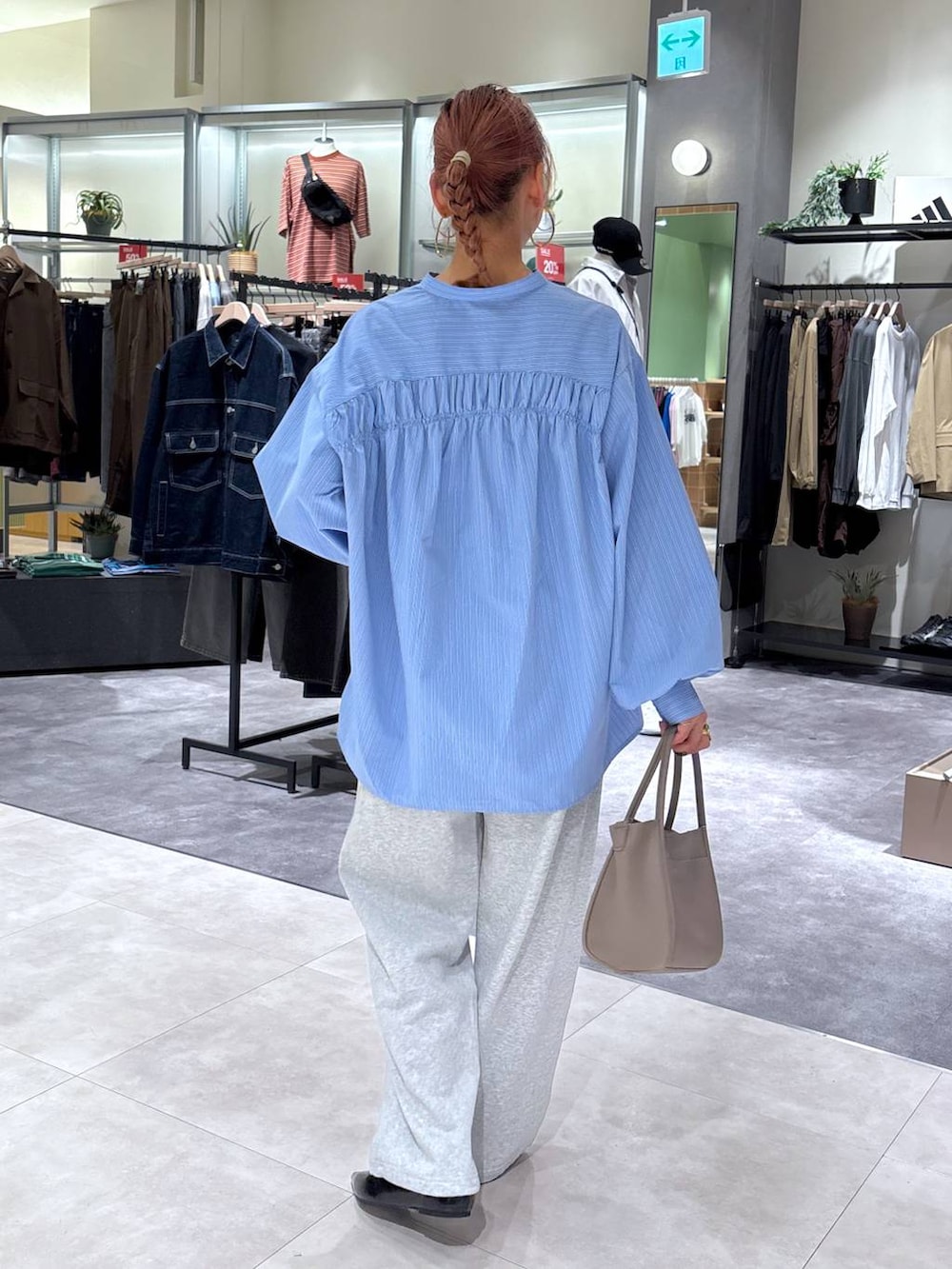 ブルー系のシャツ/ブラウス、グレー系のショルダーバッグ、ブラック系のパンプスを着用したレディースの秋コーディネートの5枚目の写真