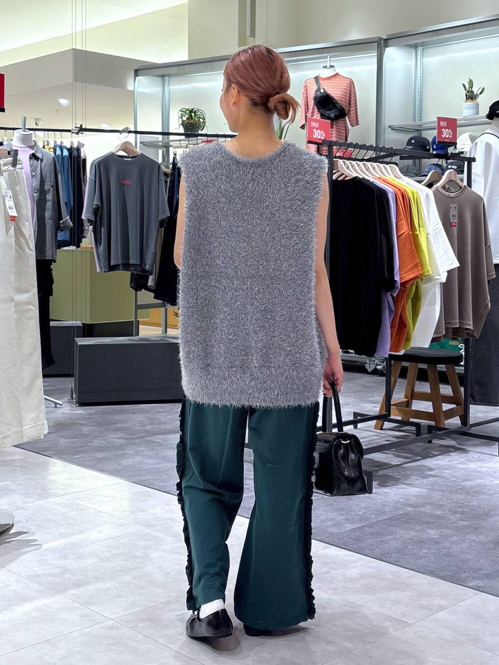 ブラック系のボストンバッグ、グリーン系のスウェットパンツ、グレー系のベストを着用したレディースの秋コーディネートの5枚目の写真