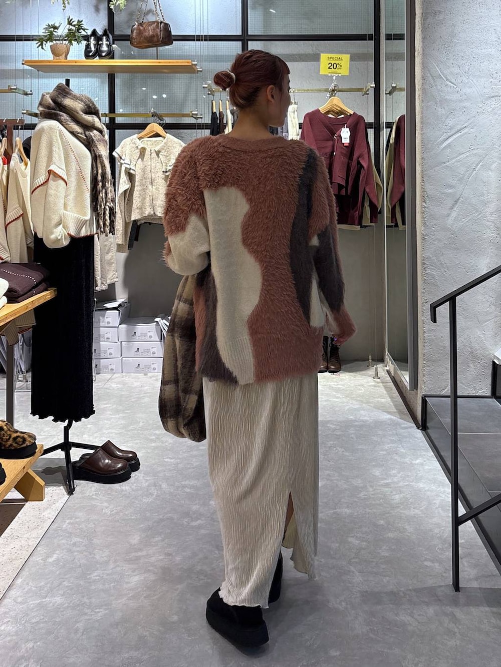 ピンク系のカーディガン/ボレロ、ゴールド系のタンクトップ、ホワイト系のスカートを着用したレディースの秋コーディネートの5枚目の写真