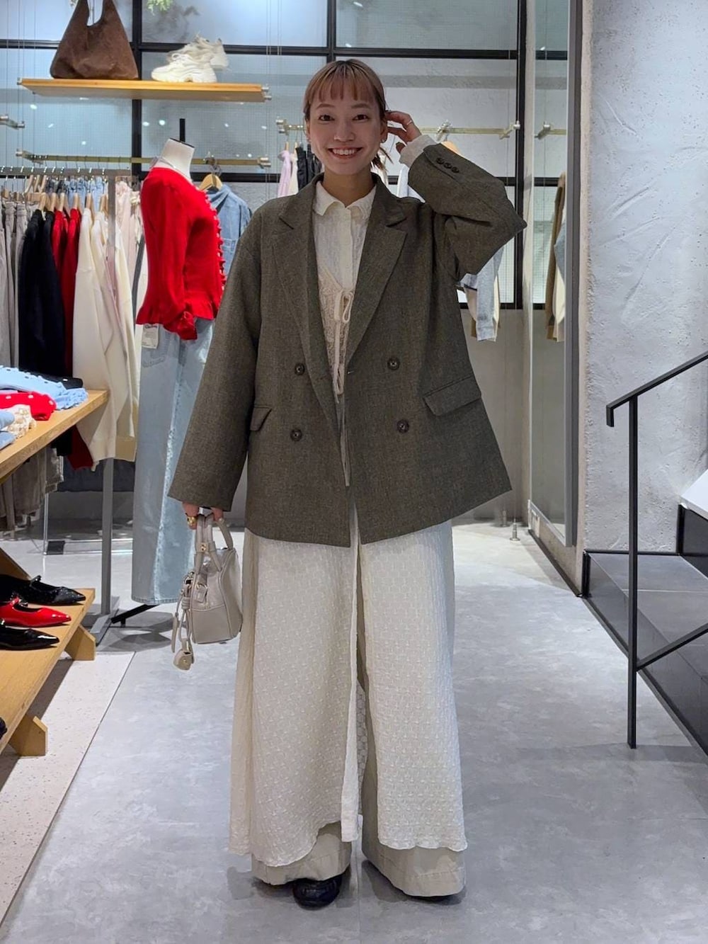 ブラウン系のテーラードジャケット、ホワイト系のボストンバッグ、ブラック系のローファーを着用したレディースの冬コーディネートの2枚目の写真